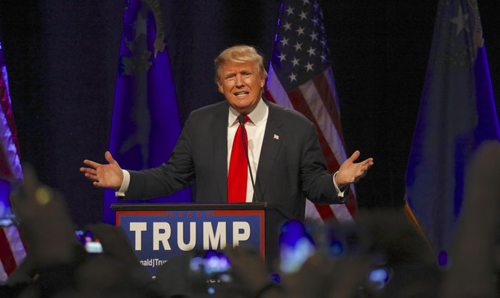 Trump står i en talarstol och gestikulerar.