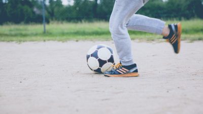 Tva fotter som springer med en fotboll framf;r sig.