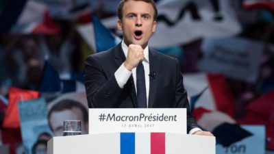Macron står i en talarstol med knuten näve.