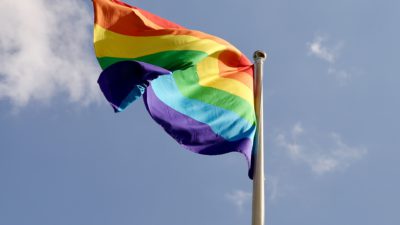 Flagga med regnbågens färger.
